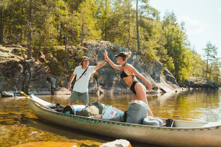 Zwei glückliche Freunde machen die Kanu-Tour in Schweden.
