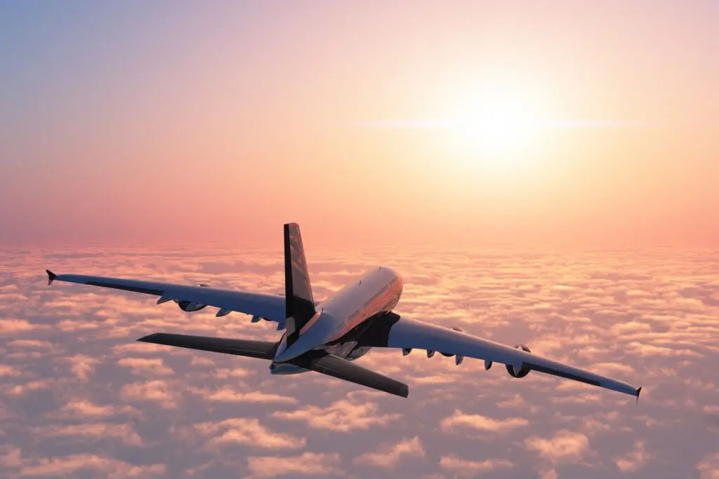 Flugzeug über den Wolken bei Sonnenuntergang