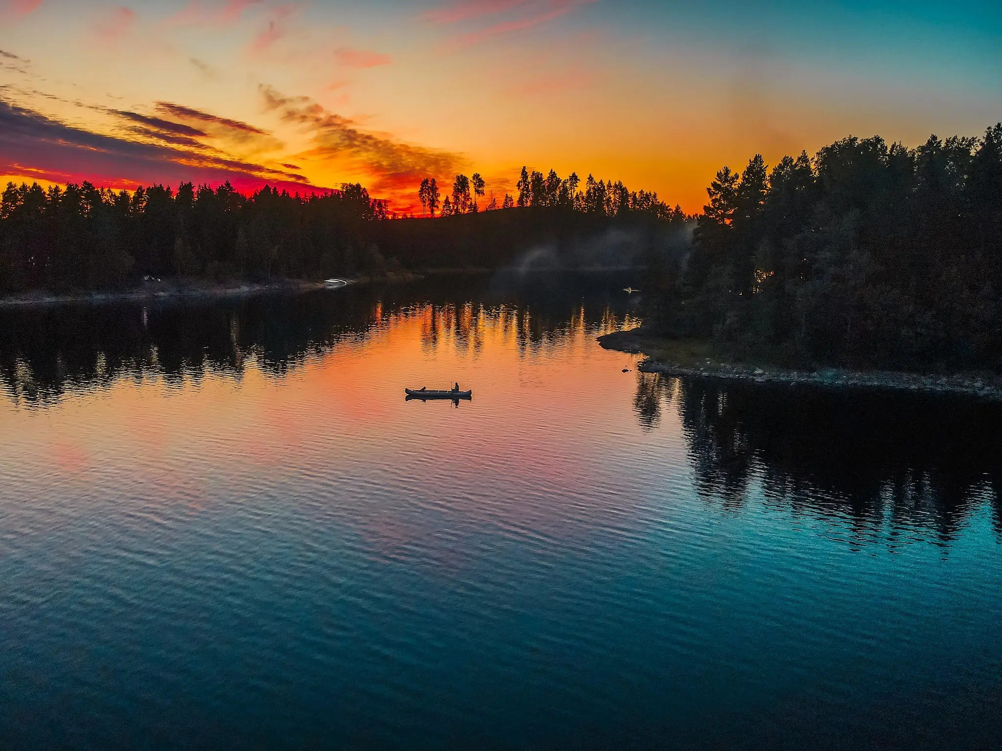 canoe on a lake at sunset with forest